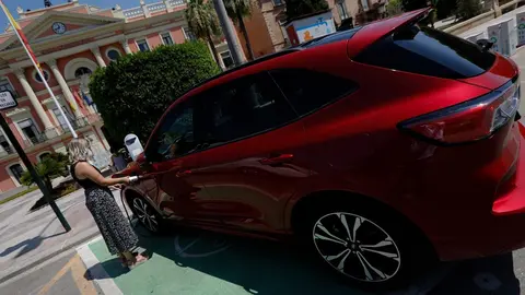 Una persona recarga un coche el&eacute;ctrico en un punto de recarga.