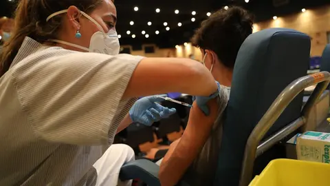 Una sanitaria vacuna a un menor  contra el coronavirus con una dosis de Pfizer