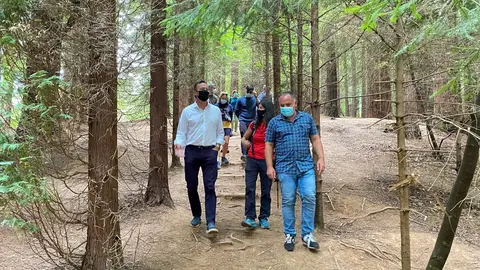 El consejero de Desarrollo Rural y Medio Ambiente, Guillermo Blanco (izda), participa junto con el alcalde de Cabez&oacute;n de la Sal, V&iacute;ctor Reinoso, en una ruta de 'Naturea' por el Bosque de Secuoyas