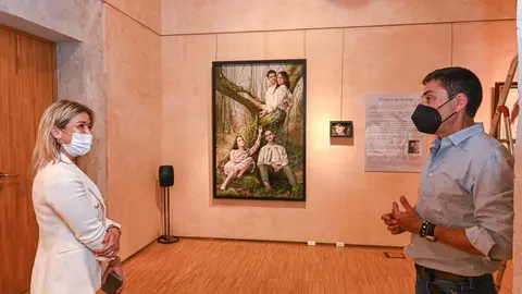 La concejala de Cultura y Turismo, Eva Cobo, y el pintor &Oacute;scar Calleja frente al cuadro que da t&iacute;tulo a la exposici&oacute;n, 'El &aacute;rbol de la vida'.