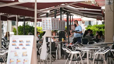 Archivo - Un camarero atiende una mesa en la terraza de una cafeter&iacute;a