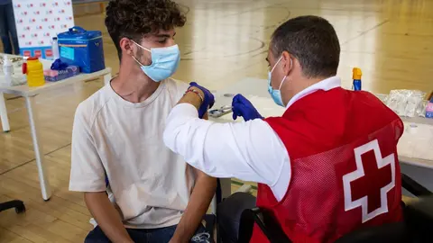Un voluntario de Cruz Roja administra una dosis de la vacuna contra el Covid-19 a un estudiante universitario en el campus de Ciudad Universitaria, a 14 de septiembre de 2021, en Madrid, (Espa&ntilde;a). 