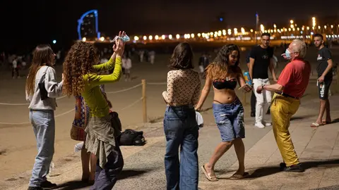 Archivo - Un grupo de chicas y un se&ntilde;or bailan a pi&eacute; de playa, a 27 de junio de 2021, en Barcelona, Catalunya (Espa&ntilde;a). Este jueves 24 de junio, en un Consejo de Ministros extraordinario, el Gobierno de Espa&ntilde;a aprob&oacute; que las mascarillas dejasen de ser obl