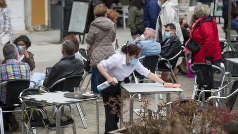 Ribadeo, Lugo. Primer dia tras el fin del Estado de Alarma en toda Espa&ntilde;a. Desde hoy domingo se puede de nuevo pasar de una Comunidad Aut&oacute;noma a otra. En la im&aacute;gen, una trabajadora limpia la mesa de una terraza de hosteler&iacute;a en la ma&ntilde;ana del domingo 9 de Mayo