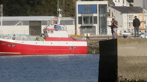 A Mari&ntilde;a, Lugo. El reciente veto de la UE a la faena de los barcos arrastreros en m&aacute;s de 70 caladeros, aboca a centenares de barcos al paro forzoso y a un proyecto econ&oacute;mico inviable. Representantes del sector exigen a las administraciones que recurran la euroorden y anuncian movilizaciones en defensa del sector. En la imagen, varios pescadores observan el muella del Puerto de Celeiro, Viveiro, en la tarde del lunes 3 de octubre