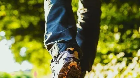 Closeup of male legs hiking in nature.