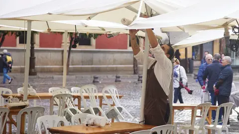 Un camarero pone los calefactores en una terraza en el puente del mes de diciembre en Sevilla, a 9 de diciembre de 2022 en Sevilla (Andaluc&iacute;a, Espa&ntilde;a). Los comercios de la ciudad de Sevilla han tenido que ver reducido sus ingresos por las precipitaciones desde el pasado lunes.