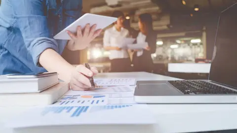 Asian business people meeting with new startup project pointing graph discussion and analysis data charts and graphs.Business finances and accounting concept