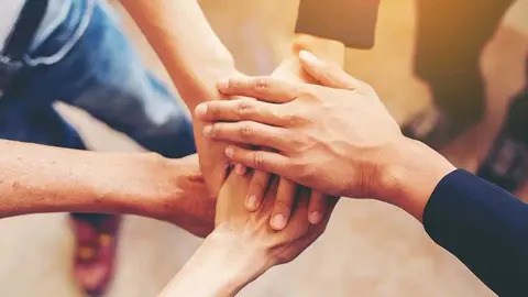 Concept of teamwork: Close-Up of hands business team showing unity with putting their hands together.