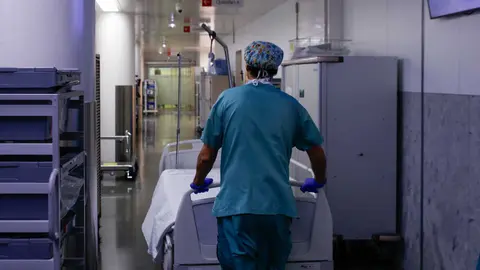 Un celador transporta una camilla vac&iacute;a en el pasillo intervenido como zona limpia y que comunica todos los quir&oacute;fanos.